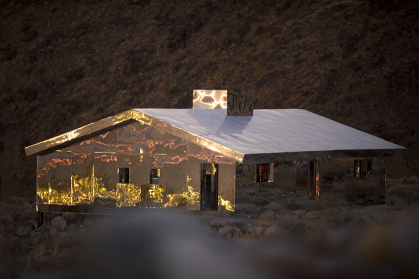 A mirrored house glowing with reflected desert light