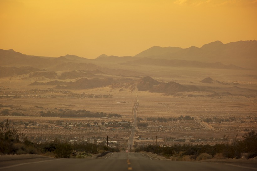 A desert valley in golden haze, ridges fading into the distance
