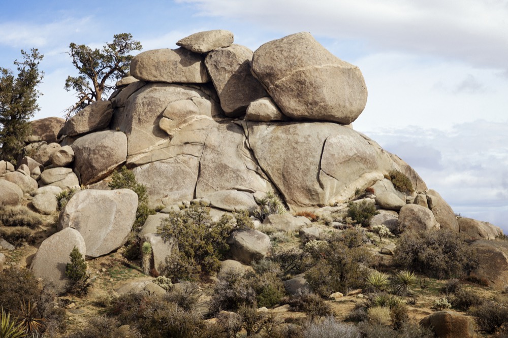 A stacked granite outcrop above desert scrub under a big sky