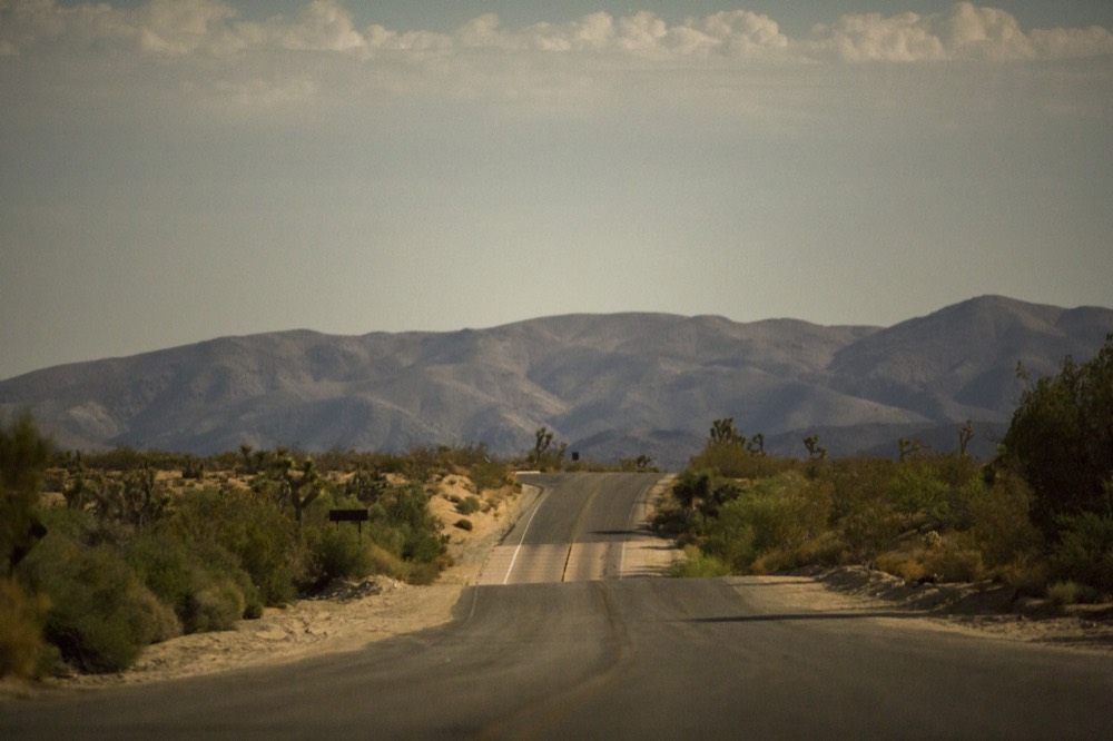 A road running straight across the desert toward the mountains