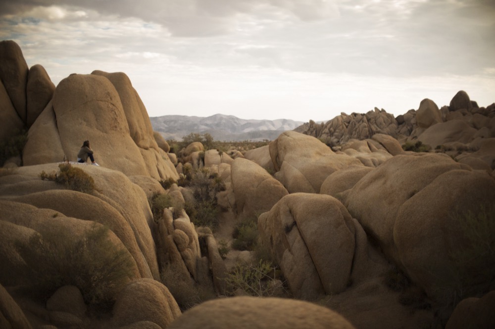 A lone figure on the boulders in the last light