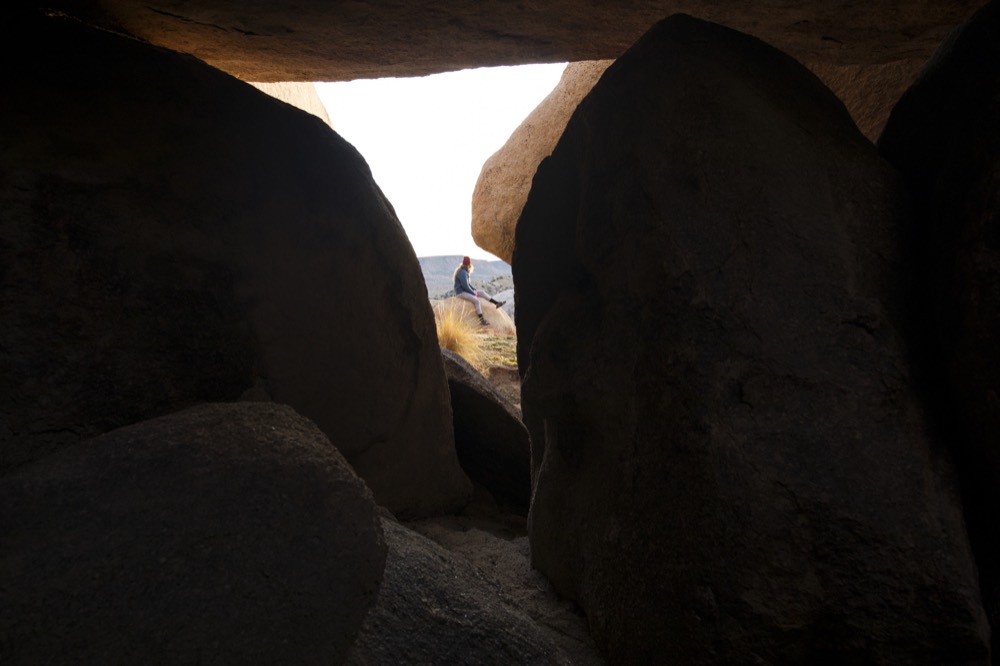 Looking out through a gap between dark boulders
