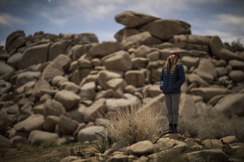 A walker standing among boulders under a wide sky